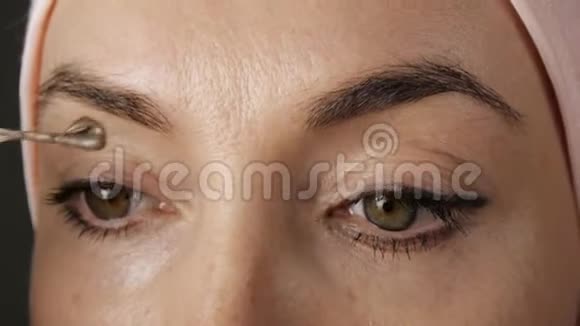 染眉毛在眉毛上涂上棕色油漆的特写视频的预览图