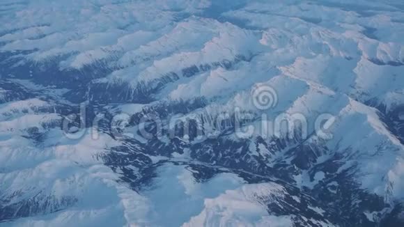 在冬季日落时飞越阿尔卑斯山从飞机窗口可以看到空中景色视频的预览图