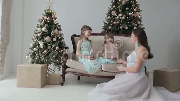 新年快乐的孩子和妈妈在玩圣诞礼物视频的预览图