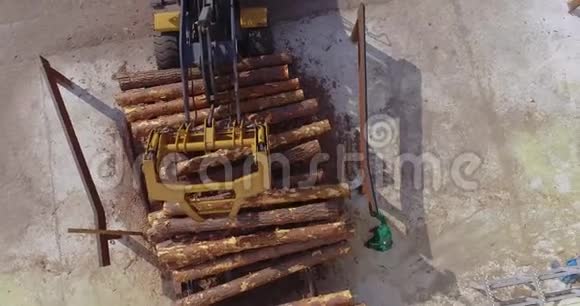 锯木厂的工作流程推土机在一家木工工厂的输送机上卸下原木视频的预览图
