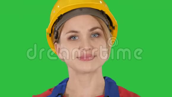 穿着黄色硬帽走在绿色屏幕上的年轻女人Chroma键视频的预览图