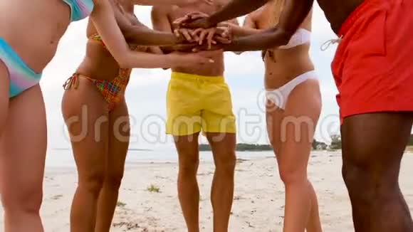 快乐的朋友在夏天的沙滩上叠手视频的预览图