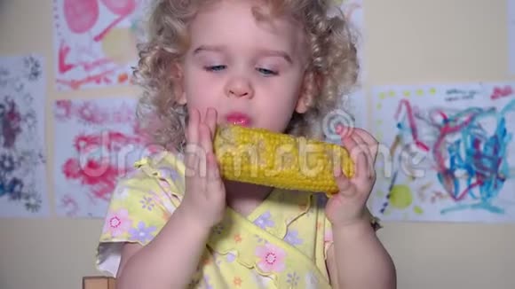 幼儿可爱的女孩吃煮玉米飞行摄像机视频的预览图