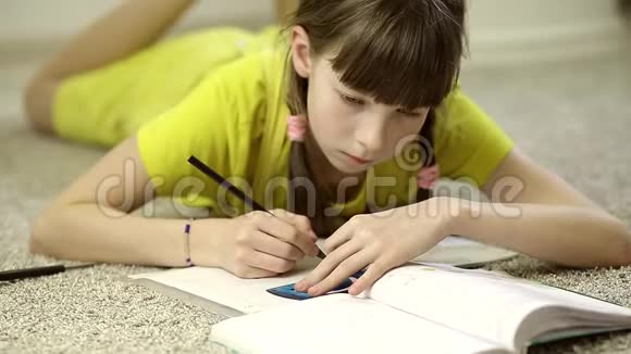 坐在房间地毯上做作业的少女视频的预览图