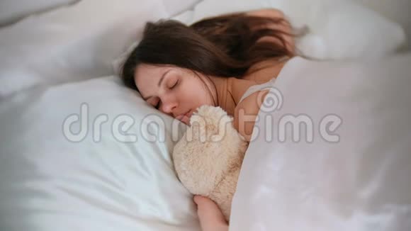 年轻的女人和玩具熊睡觉视频的预览图