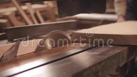 瞄准正在进行中的圆锯的镜头木匠在锯木头做形状木屑慢动作视频的预览图