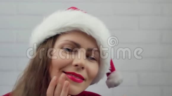 祝2018年新年快乐圣诞老人女孩用口红在2018年的玻璃单词上写字戴着圣诞帽的漂亮女孩在发信息视频的预览图