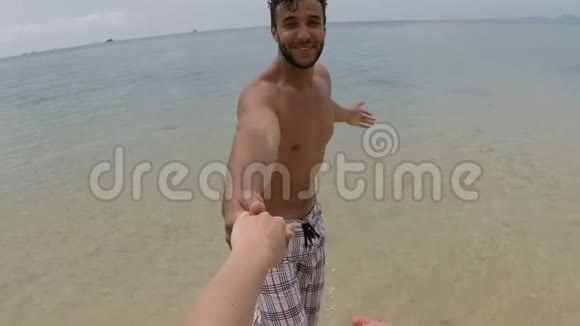 西班牙裔男子在海边的一对年轻夫妇手牵着手的镜头奔跑视频的预览图