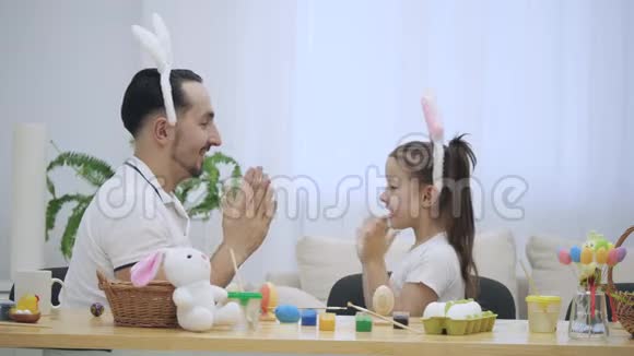 父亲正在和他的女儿玩游戏他们正在玩他们的手漂亮有趣幼稚的游戏视频的预览图