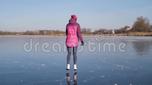 在一个寒冷的冬天年轻女子在冰冻的湖面上滑冰人冬季运动休闲理念视频的预览图