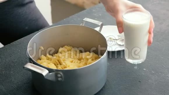 特写女人手做土豆泥加入牛奶与平底锅中的搅拌机混合做土豆泥视频的预览图