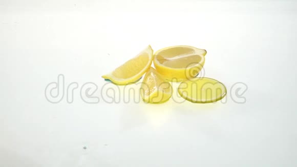 柠檬片在水上滚动到剩余的水果上白色背景慢动作视频的预览图