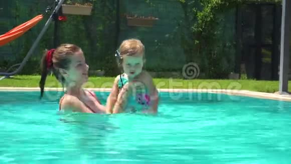 女人和小女孩在游泳池游泳视频的预览图