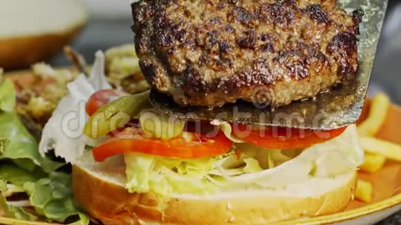 一个大汉堡包放在面包上里面有慢动作的蔬菜视频的预览图
