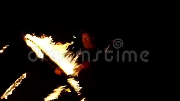 年轻的行凶抢劫者在夜晚缓慢地转动一个用火焰包围自己的立方体视频的预览图