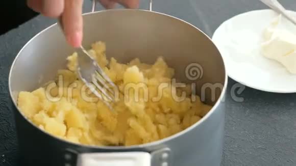 特写女人手做土豆泥加入黄油和盐然后混合做土豆泥视频的预览图