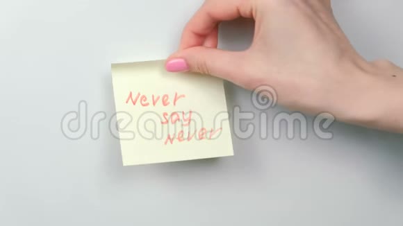 特写的女人她的手贴着黄色的贴纸纸上面写着永远不会说的话视频的预览图