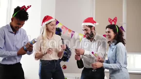 一群年轻人在办公室里庆祝圣诞节和新年开着一瓶起泡葡萄酒和啤酒视频的预览图