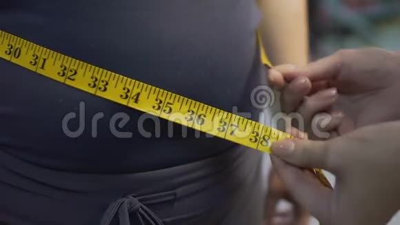 肥胖女性用绒线测量腰部减肥结果视频的预览图