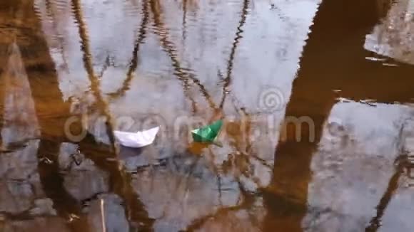 白色的绿色的纸船在河上航行视频的预览图