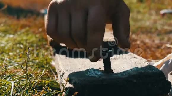 男性手指把坚果拧成木板视频的预览图