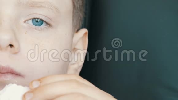 蓝眼睛雀斑的少年男孩吃大甜棉花糖食糖问题糖尿病视频的预览图