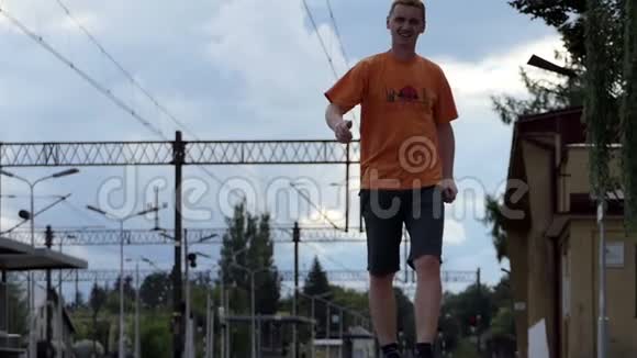 夏天一个快乐的人在斯洛文尼亚沿着铁路站台走视频的预览图
