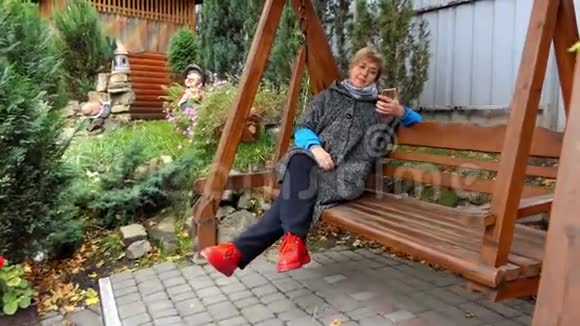 一个穿着时髦衣服的微笑的女人在长凳上游泳视频的预览图