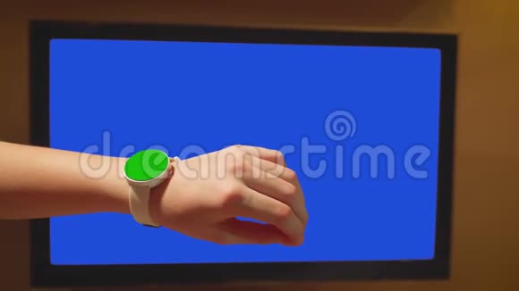 女孩触摸绿色屏幕手表背景蓝屏电视机视频的预览图