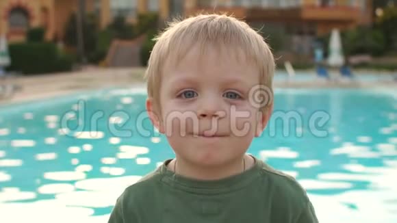 游泳池附近一个小男孩的肖像视频的预览图