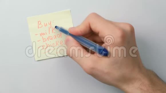 特写男的手写在黄色的贴纸纸上字啤酒代替购物清单视频的预览图
