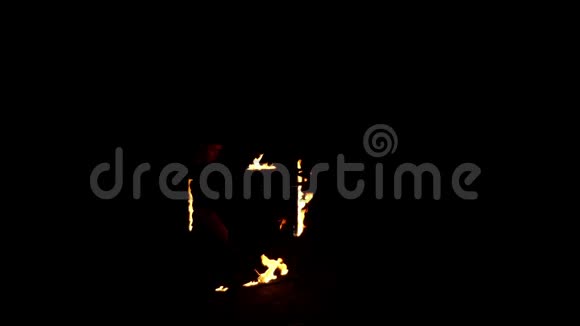年轻的魔术师点燃一个方形框架与火深在夜晚看上去很神奇视频的预览图
