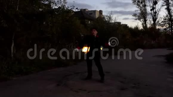 一个神奇的人在斯隆莫的夜间户外玩两个点燃的火炬视频的预览图
