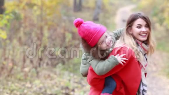 秋天快乐的母亲把女儿抱在公园里视频的预览图