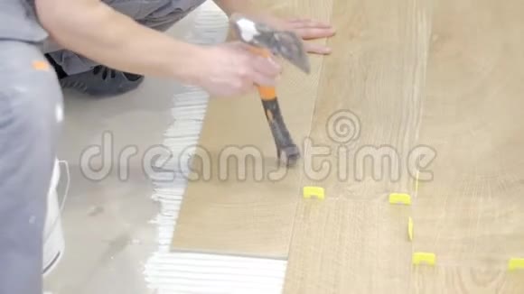 一个人把一块瓷砖放在水泥上面瓷砖的颜色是一棵橡树视频的预览图