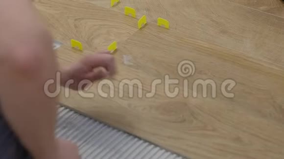 一个人把一块瓷砖放在水泥上面瓷砖的颜色是一棵橡树视频的预览图
