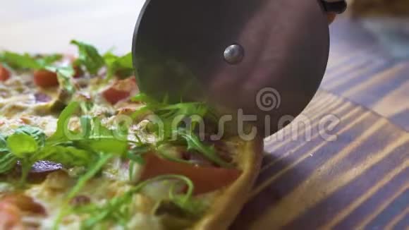 厨师用滚刀在披萨店的木桌上切披萨把比萨饼切在切片上视频的预览图