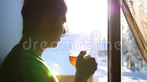 冬天寒冷的一天那家伙一大早就站在窗口喝热茶视频的预览图