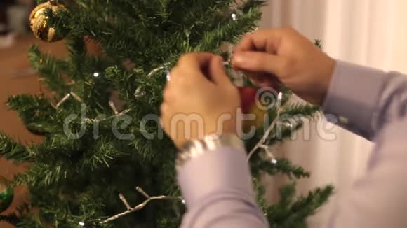 男人装饰圣诞树视频的预览图
