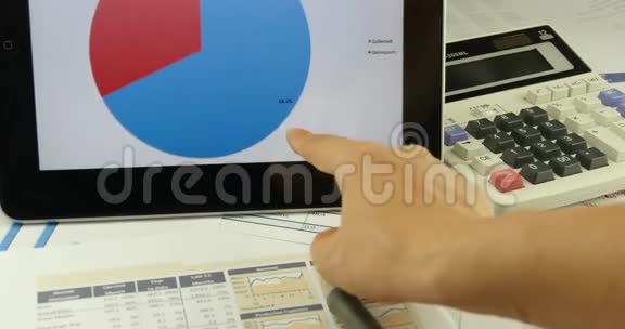 商人用图表制作平板电脑用手指触摸金融饼图视频的预览图