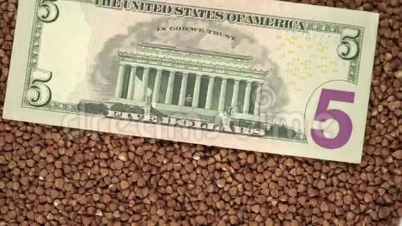 荞麦谷物与美国国家货币美元旋转在转盘上顶部视图视频的预览图