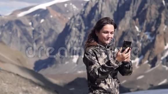 山背景上的年轻女子被拍照打电话打电话旅行者视频的预览图