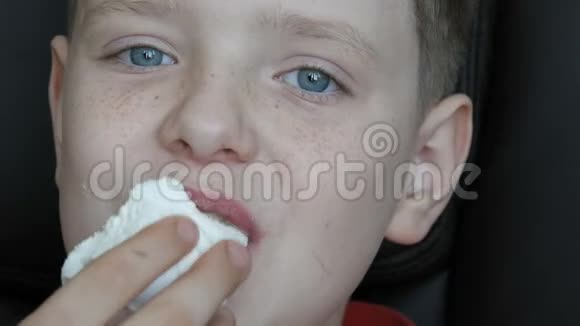 蓝眼睛雀斑的少年男孩吃大甜棉花糖食糖问题糖尿病视频的预览图