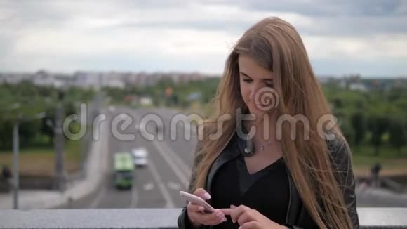 漂亮的年轻女人使用智能手机和直发视频的预览图