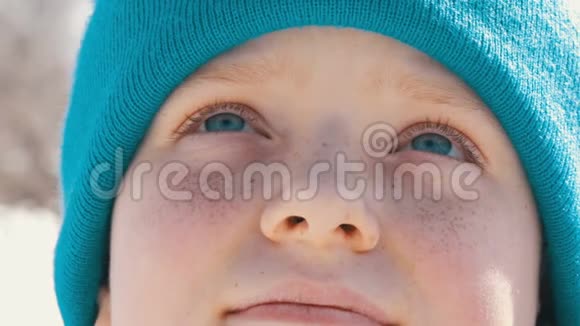 一个长着蓝眼睛脸上长满雀斑眼睛里戴着帽子的英俊少年抬头看着视频的预览图