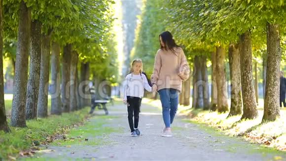 秋天的家庭年轻的母亲和小孩散步享受秋天公园里温暖的一天视频的预览图