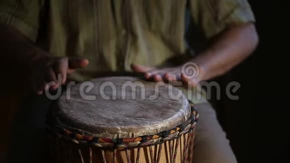 男人手在非洲皮肤覆盖的手鼓上鼓出一个节拍视频的预览图