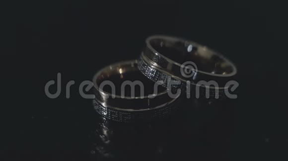 结婚戒指躺在黑桌上视频的预览图