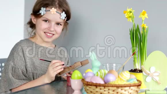 一个棕色眼睛的女孩头上戴着花环正在准备复活节孩子看着相机高兴地笑了视频的预览图