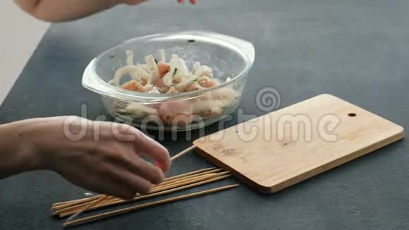 特写女人她的手煮腌制的什锦或什锦串鸡肉在木串和洋葱在木板上视频的预览图